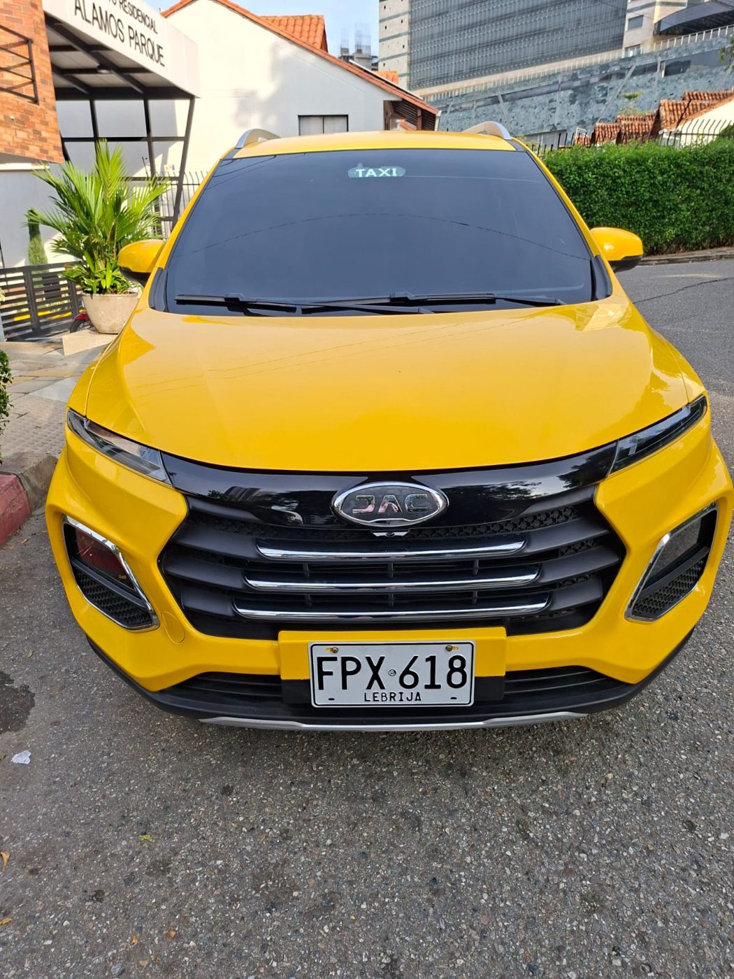 Vista frontal del taxi JAC amarillo, placa FPX618